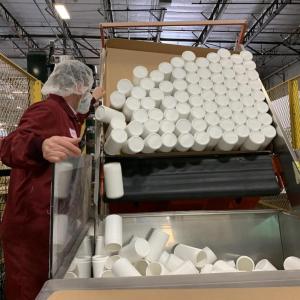 canisters being dumped into a large container in factory