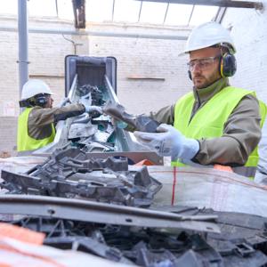 Workers sorting plastics on a conveyor belt.