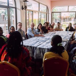 A large group of people indoors around a rectangular table
