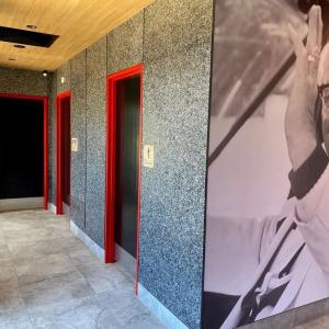 A mural on a wall  by a hallway leading to bathrooms.