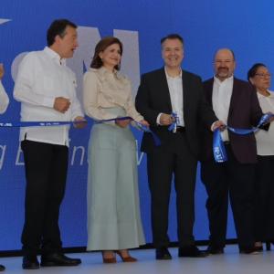 People in a line, cutting a blue ribbon.