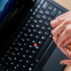 Hands holding rings over a Lenovo laptop