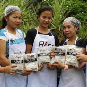Volunteers posed with bags of food. "Rise against Hunger" on their aprons.