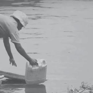 a person collects water with a jug