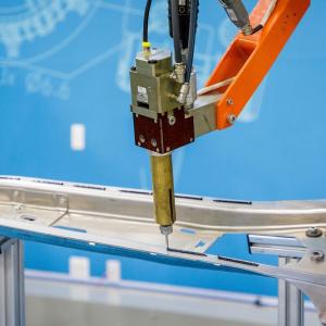Close-up robotic application of structural adhesive on car body