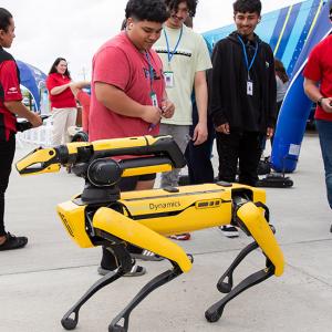 Participants outside watch a robotic animal being operated