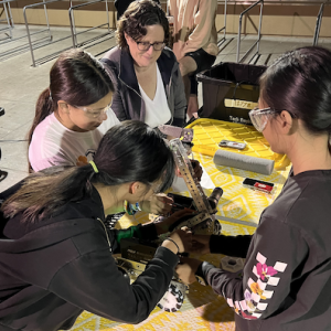A group of youth and adults working on a robot.