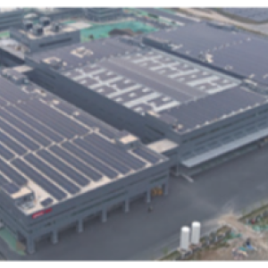 Aerial view of a large building with solar panels on the roof.