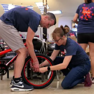 2 people adjusting a bicycle