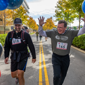 Two participants at the finish line, one with raised hands.