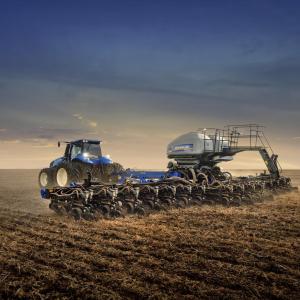 silver tractor in a golden field at dawn