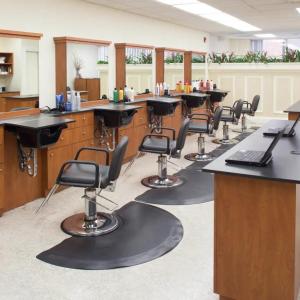 Hair salon with five chairs aligned in front of stations.