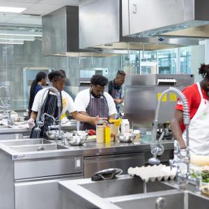Black culinary students in a commercial kitchen