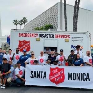 A group posed with a banner "Santa Monica Salvation Army" in front of a box truck. "Emergency Disaster Services" on the side.