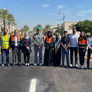 A row of people standing on a road.