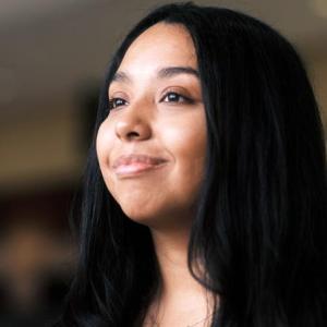 Neida Lopez smiling, looking to the distance.