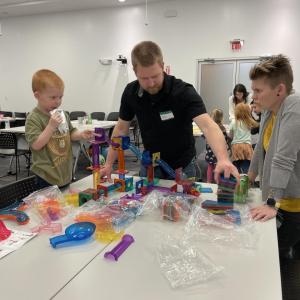 child stood pointing at the activity on the table