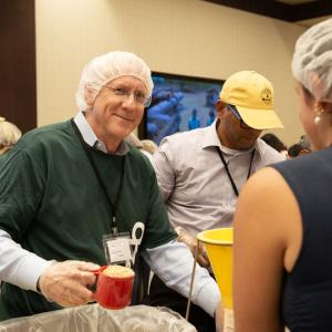 Volunteers talking as they scoop food.