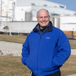Scott Hickman standing outside a large industrial plant