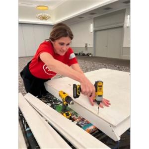 A person reaching to screw in boards.