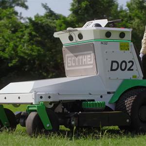 A person standing behind a Scythe mower