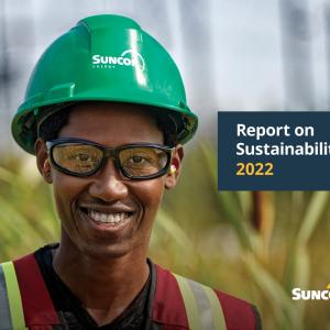 Suncor report on Sustainability 2022 with smiling person wearing a hardhat