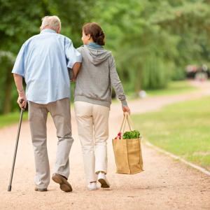 two senior citizens walking arm in arm