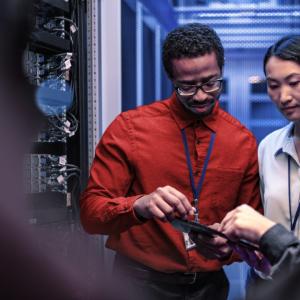 Three people working in a server room