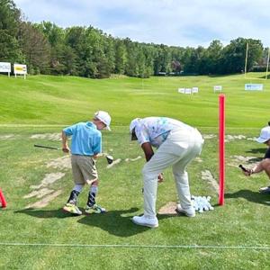 A child preparing to hit golf balls