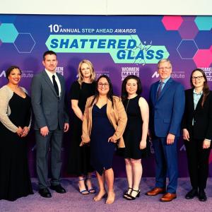 People Standing in front of a "Step Ahead Awards, Shattered Glass" Background