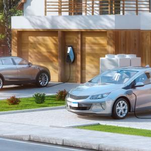 2 electric cars charging in driveways