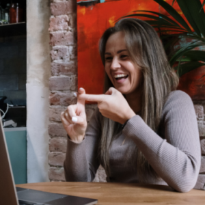 a person signing 'friend' to a laptop screen