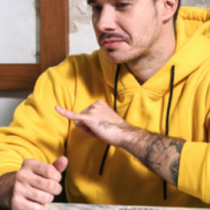 a person using a hand sign to a laptop screen