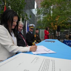 Members of the armed forces signing documents at an event