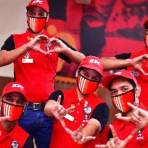 KFC employees making hearts and signs with their hands.