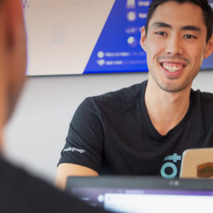 two people sitting across from each other with their laptops out