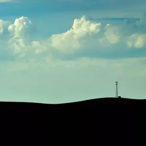 Silhouette of land with a blue cloudy sky 