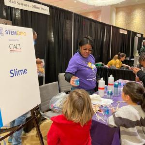 A presenter does a science experiment for onlookers.