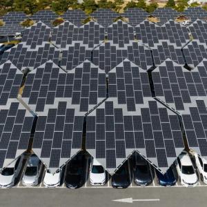 Aerial view of a parking garage roof covered in solar panels