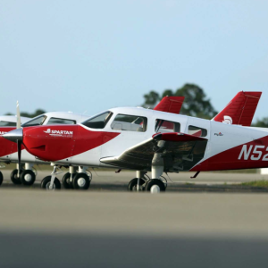 Three small planes parked on a runway