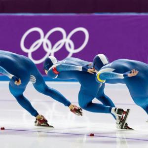 Three speed skaters on the ice.