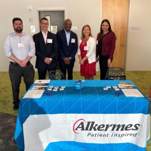Members of Alkermes’ MOSAIC employee resource group standing behind a table 