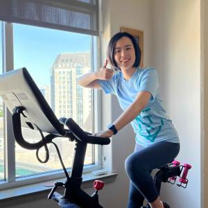 A person giving a thumbs-up on an indoor stationary bike.