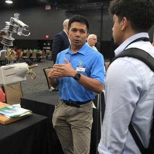 A person showing a student a piece of equipment.