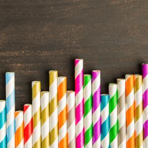 row of striped paper straws on a wood surface