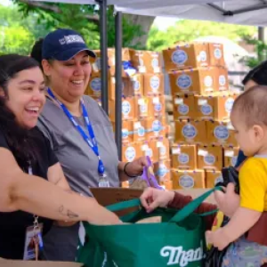 People smiling while filling a grocery bag