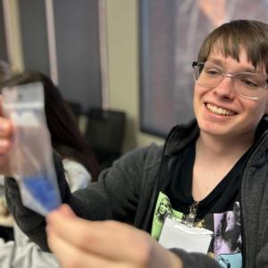 Student admires a filled sample bag.