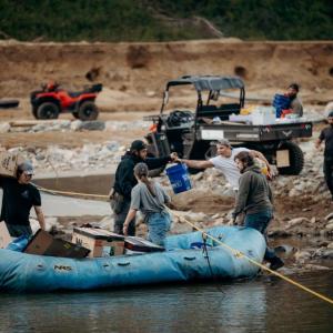 People loading supplies into an inflatable boat