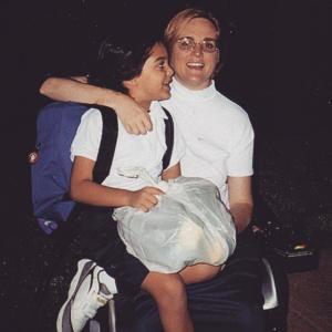 Susan Jolly and a child on her lap carrying a backpack