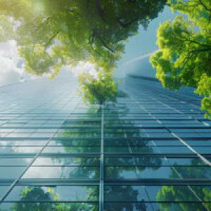 ground view of a glass building with trees and clouds